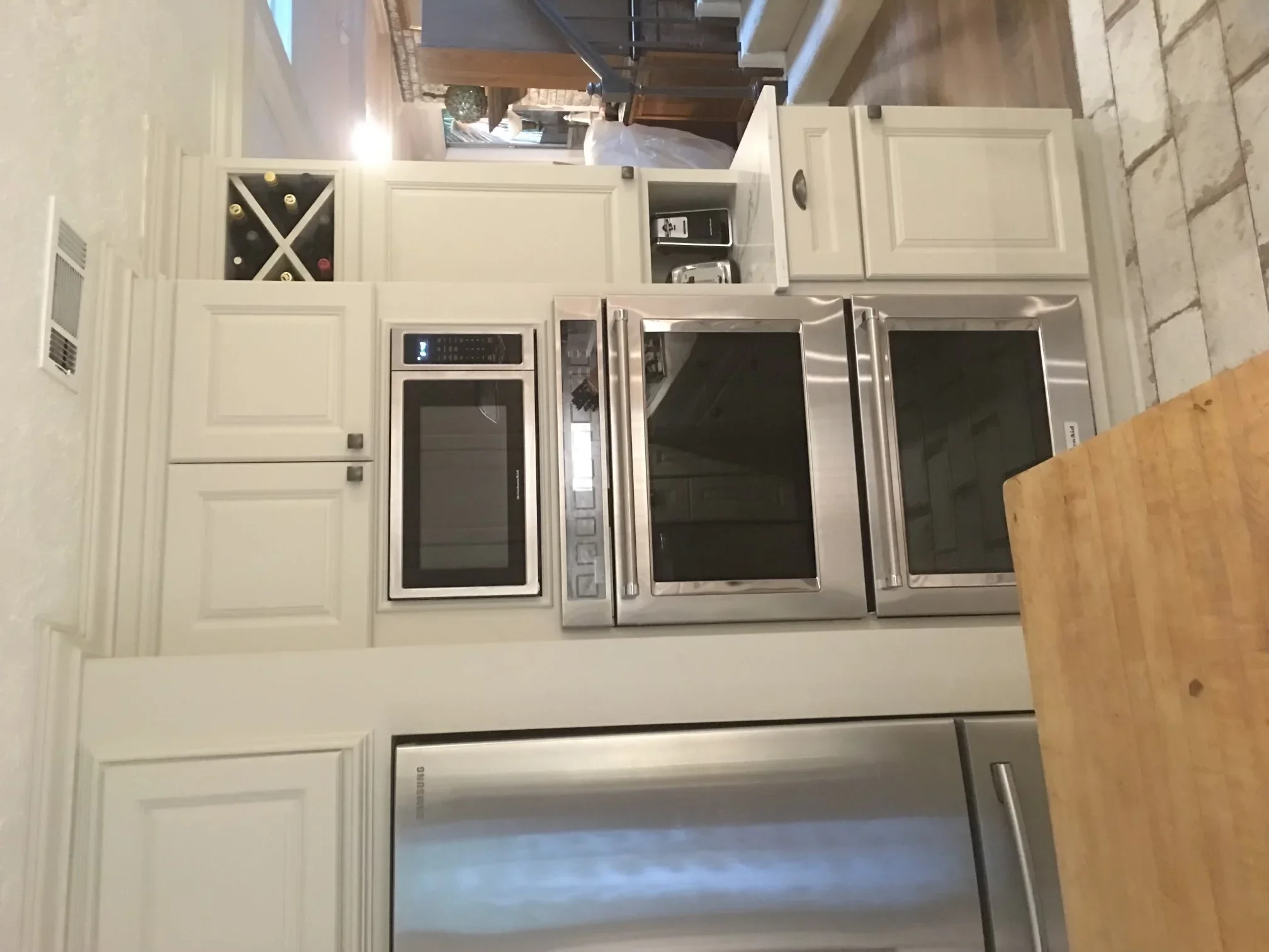 Modern kitchen with cream cabinetry, stainless steel appliances, and white countertops
