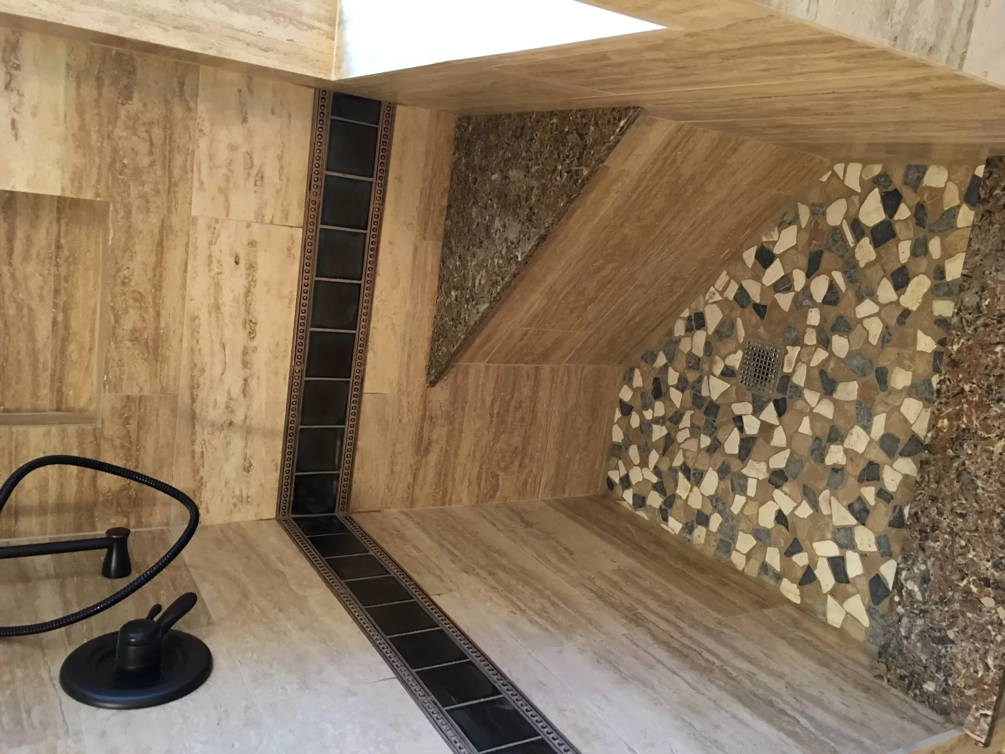 Modern bathroom with wood-look tile flooring and geometric mosaic shower wall